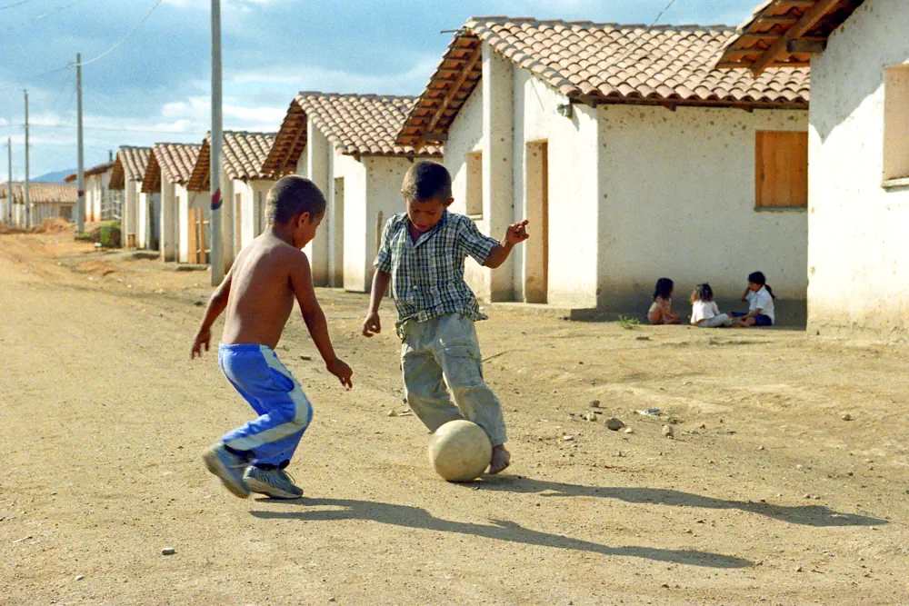 Twee kinderen spelen voetbal op straat